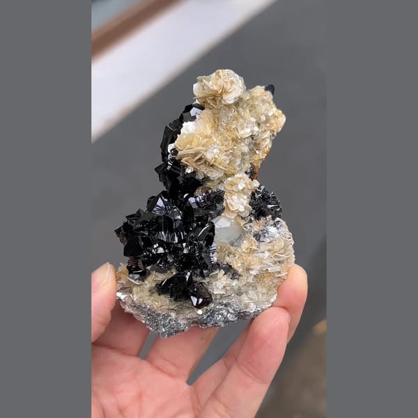 Glossy black cassiterite with aquamarine and mica from Xuebaoding, Sichuan — alternate view
