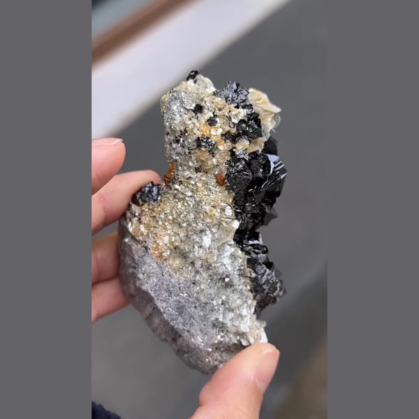 Glossy black cassiterite with aquamarine and mica from Xuebaoding, Sichuan — detail view
