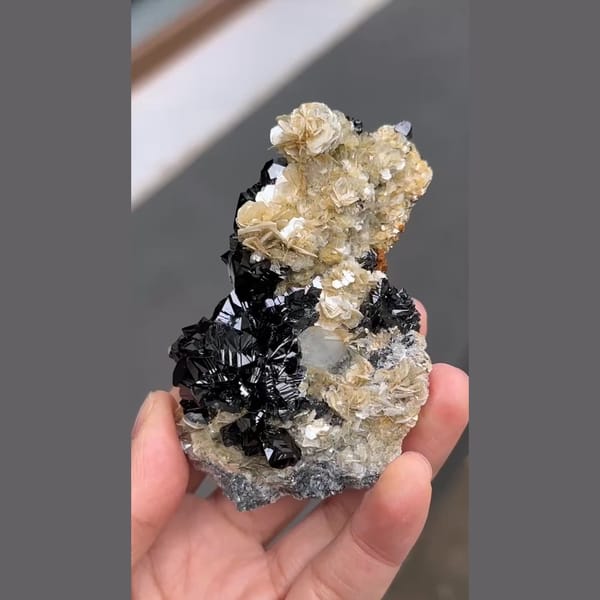 Glossy black cassiterite with aquamarine and mica from Xuebaoding, Sichuan — detail view