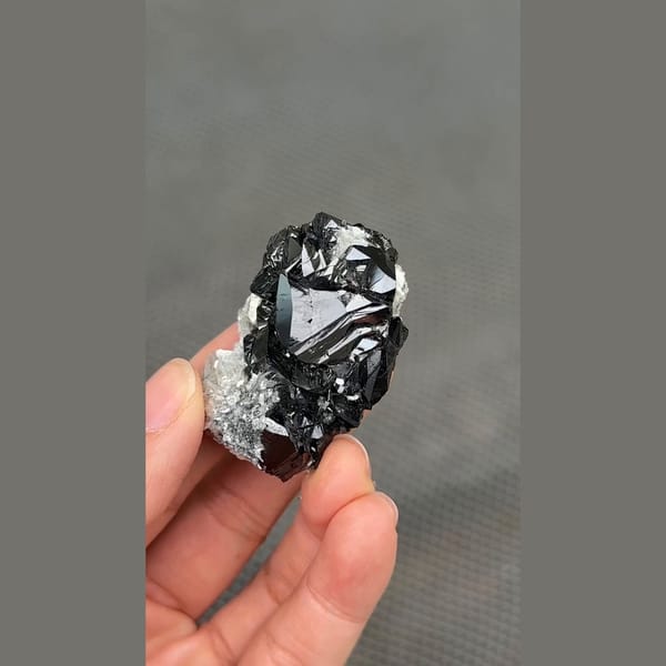 Glossy black cassiterite crystal cluster from Xuebaoding, Sichuan — complete view