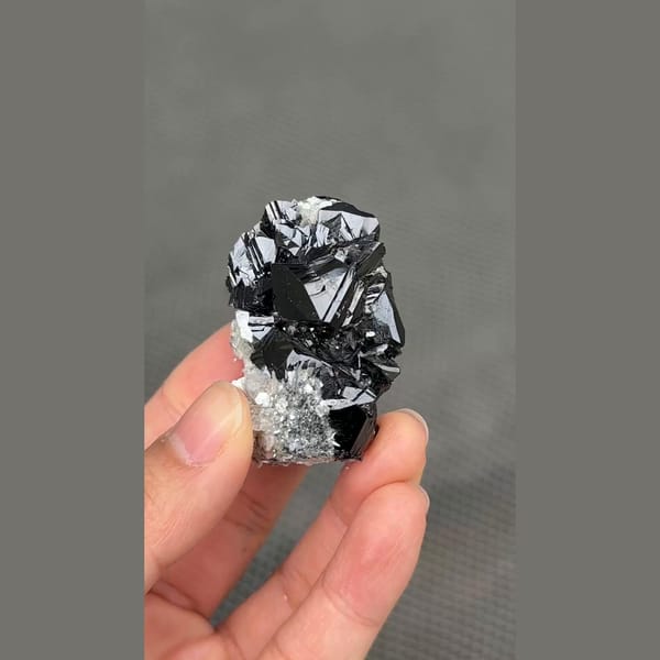 Glossy black cassiterite crystal cluster from Xuebaoding, Sichuan — alternate view