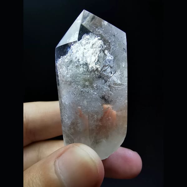 Polished enhydro clear quartz point with a water bubble — complete view