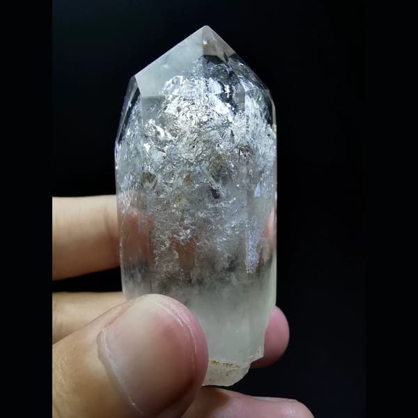 Polished enhydro clear quartz point with a water bubble — alternate view