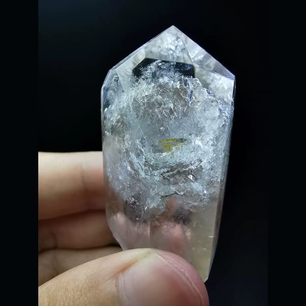 Polished enhydro clear quartz point with a water bubble — detail view