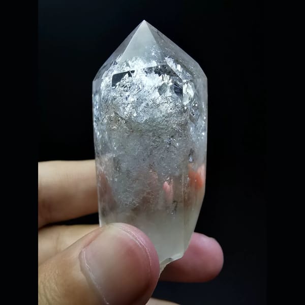 Polished enhydro clear quartz point with a water bubble — detail view