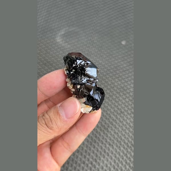Mirror-bright black cassiterite crystal group from Xuebaoding, Sichuan — complete view