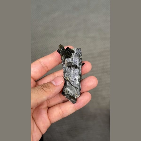Long dark lustrous epidote crystals with white zeolite — detail view