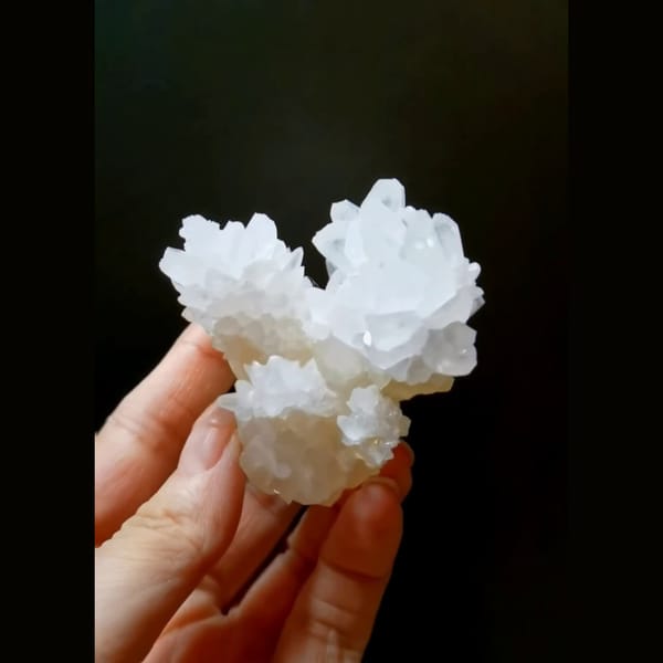 White cauliflower calcite flower with cyan UV glow — complete view