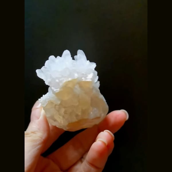 White cauliflower calcite flower with cyan UV glow — alternate view
