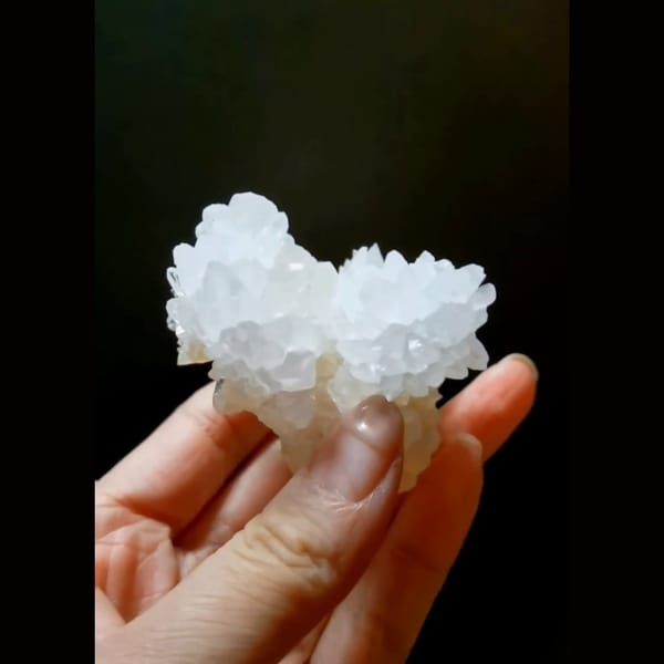 White cauliflower calcite flower with cyan UV glow — detail view