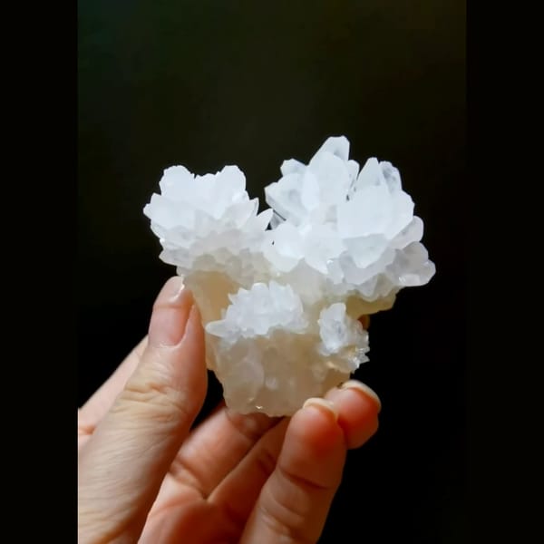 White cauliflower calcite flower with cyan UV glow — detail view