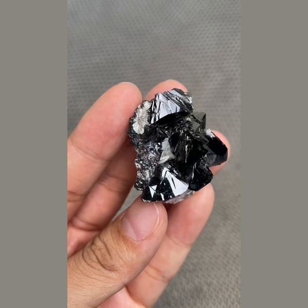 Branching cluster of lustrous black cassiterite from Xuebaoding, Sichuan — alternate view
