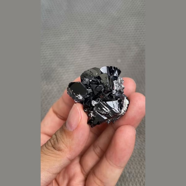 Branching cluster of lustrous black cassiterite from Xuebaoding, Sichuan — detail view