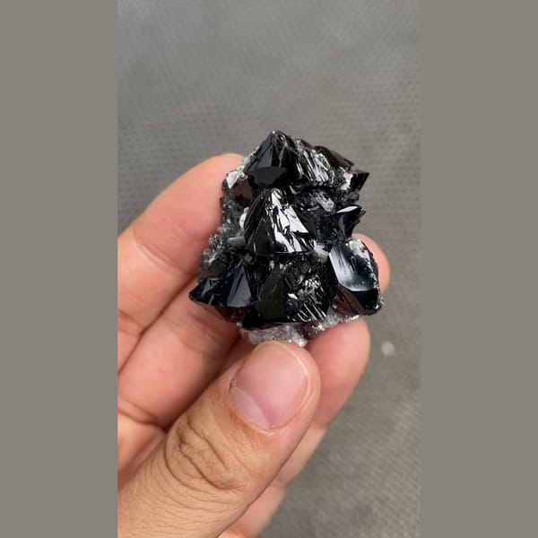 Branching cluster of lustrous black cassiterite from Xuebaoding, Sichuan — detail view