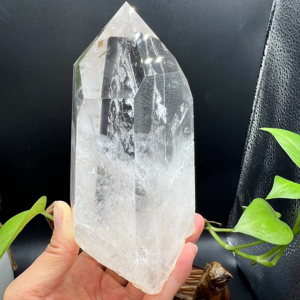 Clear quartz point with enclosed green tourmaline and white phantoms — complete view