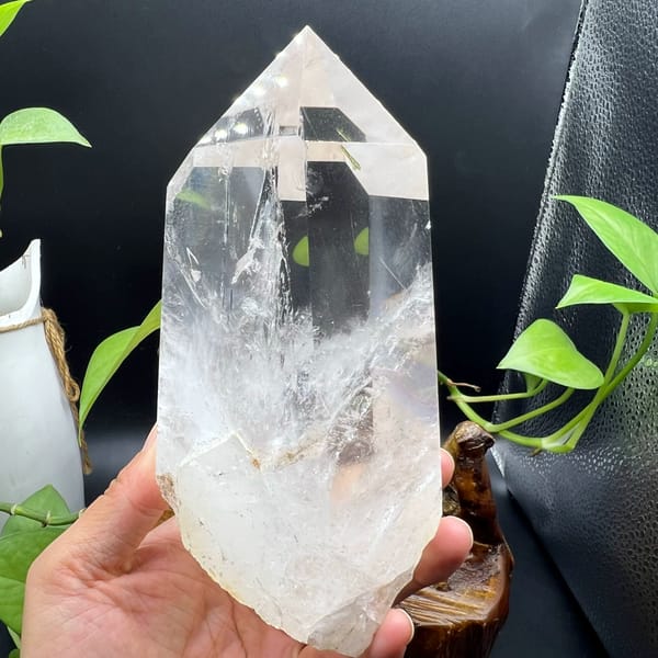 Clear quartz point with enclosed green tourmaline and white phantoms — detail view