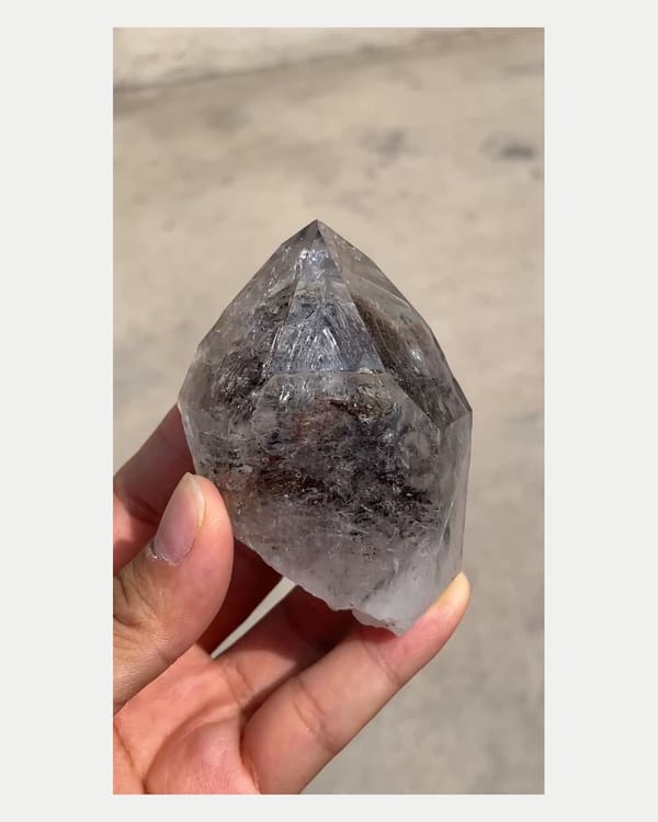 Complete front view of dark included quartz point