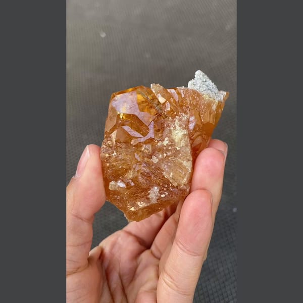 Orange scheelite floater with translucent tip from Xuebaoding, Sichuan — alternate view