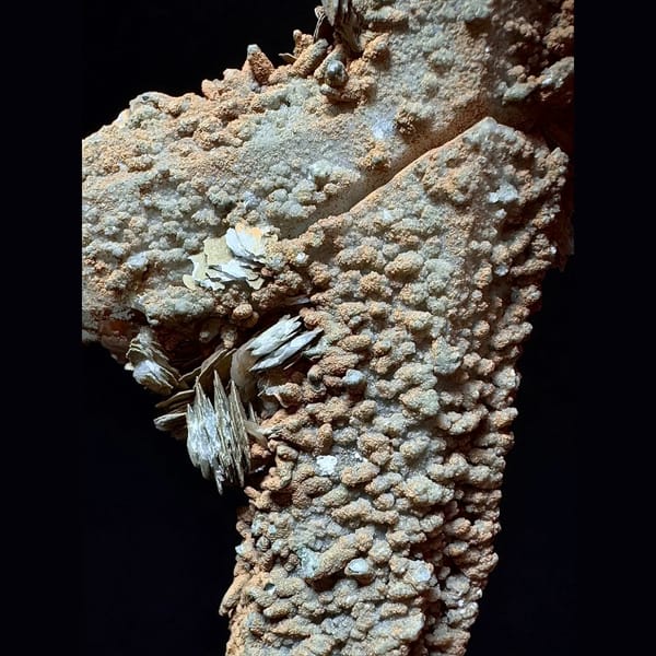 Mud-coated quartz floater with petal calcite from Inner Mongolia — detail view