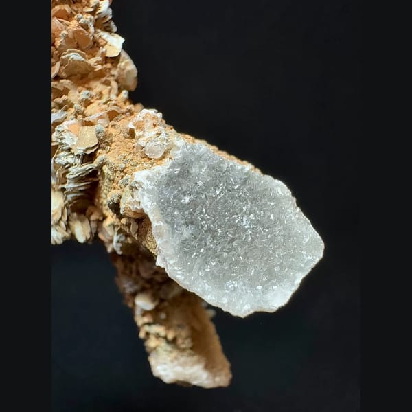 Mud-coated quartz floater with petal calcite from Inner Mongolia — detail view
