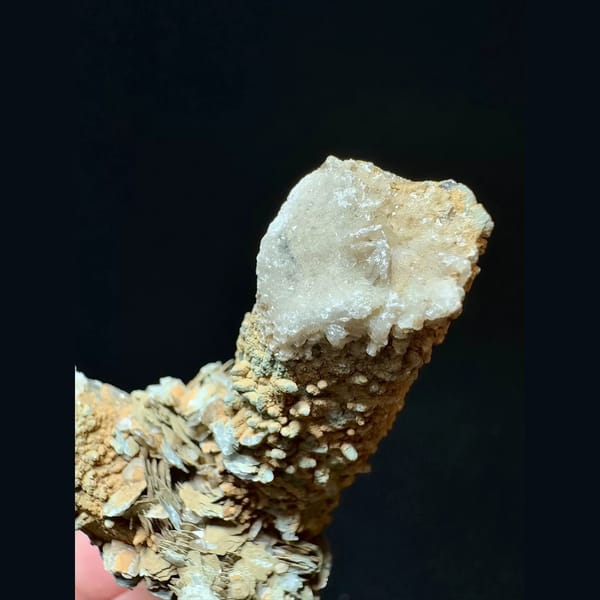 Mud-coated quartz floater with petal calcite from Inner Mongolia — detail view
