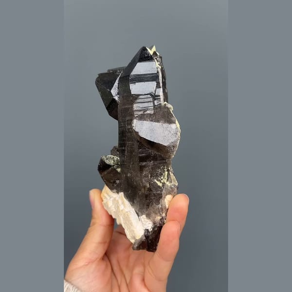 Tall near-black morion smoky quartz on cream feldspar from Wulian, Shandong — alternate view