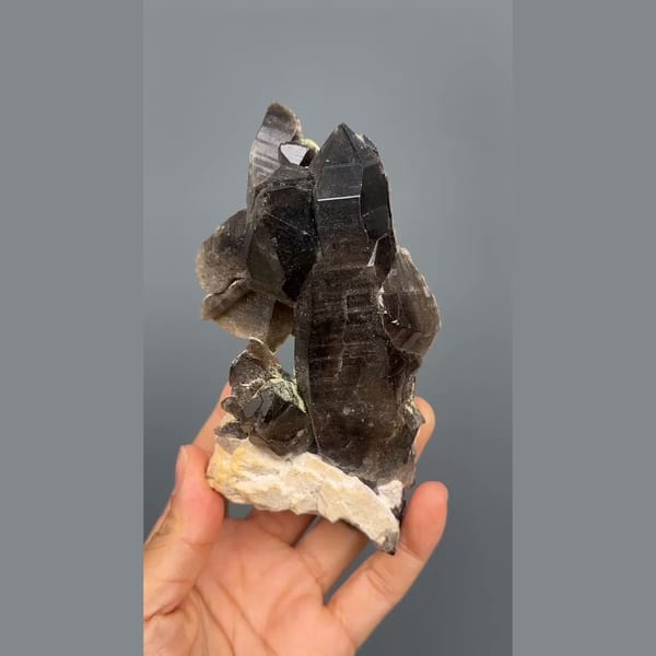 Tall near-black morion smoky quartz on cream feldspar from Wulian, Shandong — detail view