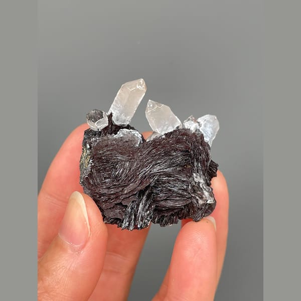 Clear quartz points on lustrous specular hematite from Guangdong — complete view