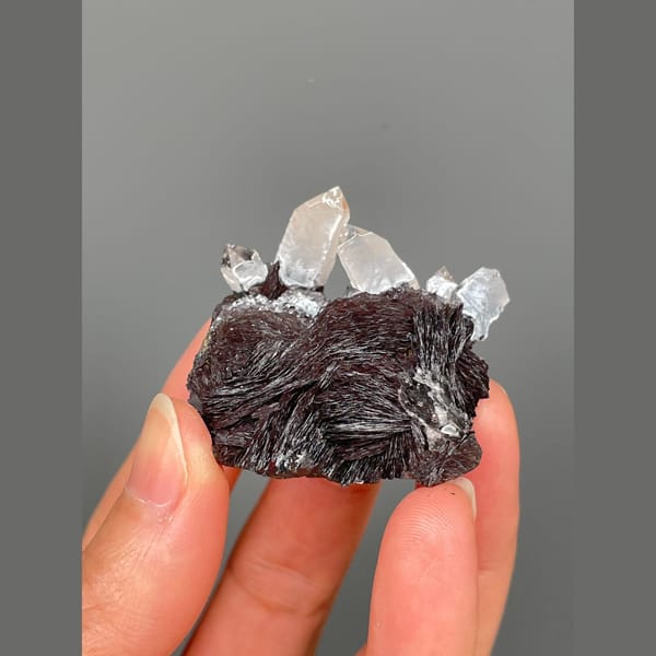 Clear quartz points on lustrous specular hematite from Guangdong — alternate view