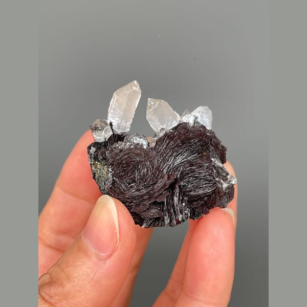 Clear quartz points on lustrous specular hematite from Guangdong — detail view