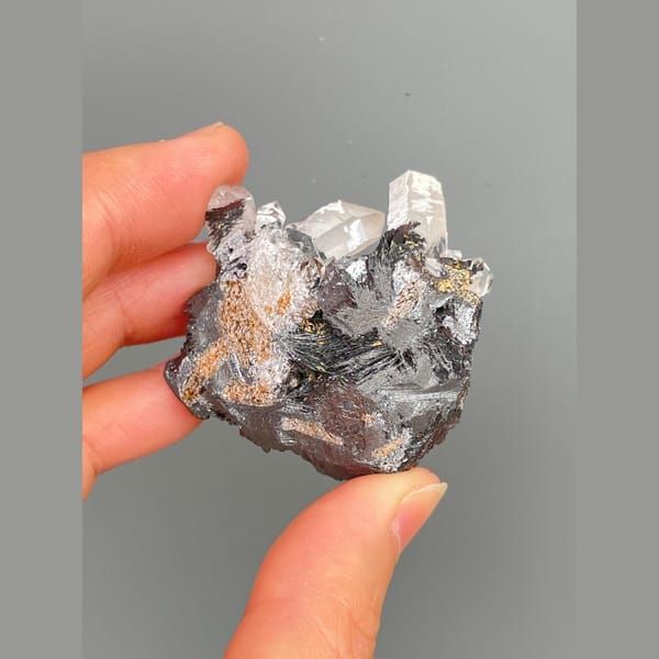 Clear quartz points on lustrous specular hematite from Guangdong — detail view
