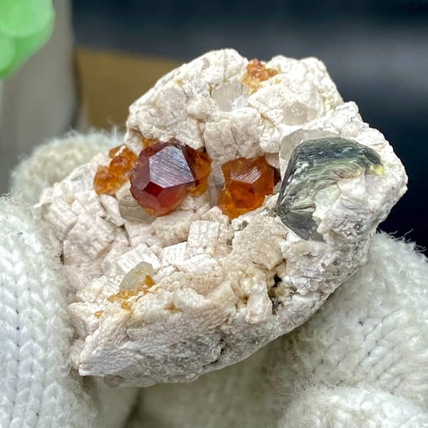 Orange red garnet clusters in feldspar with mica — detail view