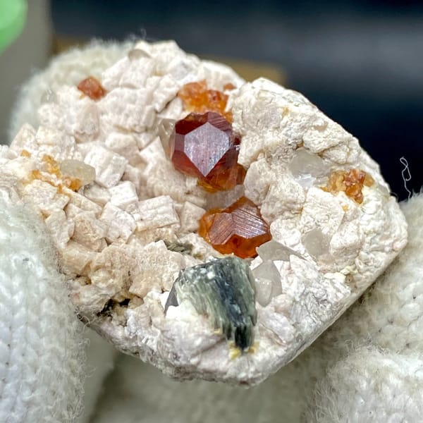 Orange red garnet clusters in feldspar with mica — detail view