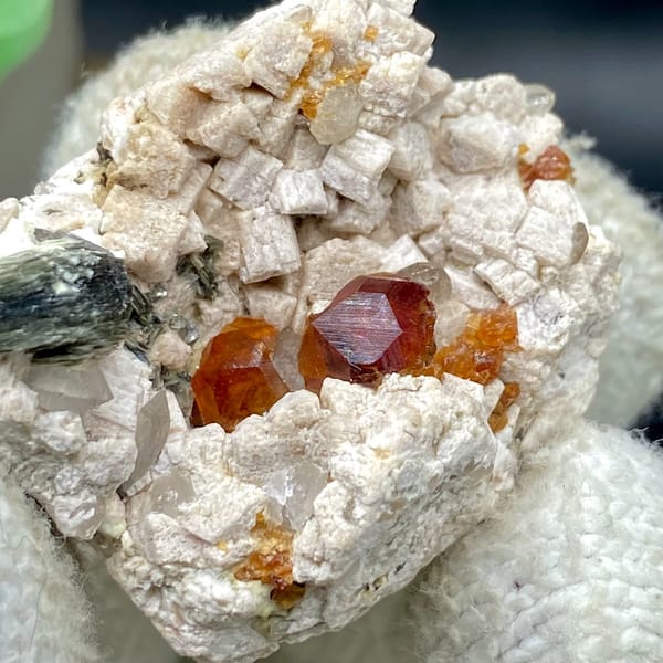 Orange red garnet clusters in feldspar with mica — detail view
