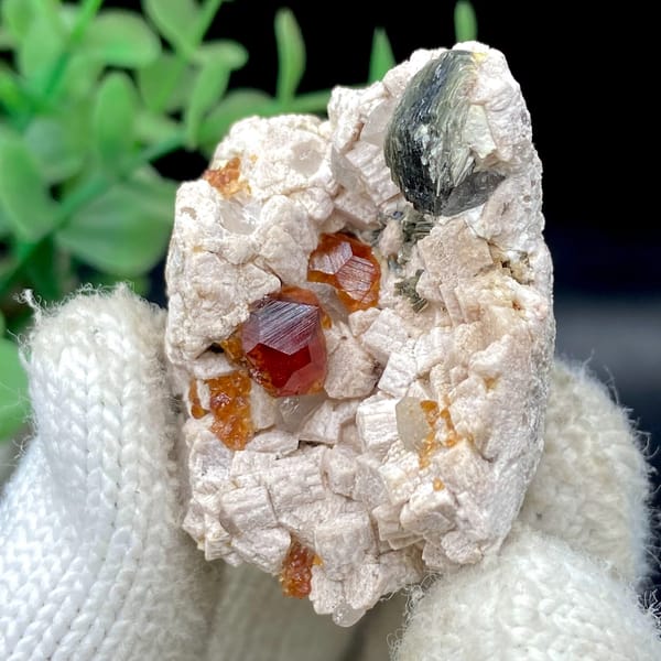 Orange red garnet clusters in feldspar with mica — detail view