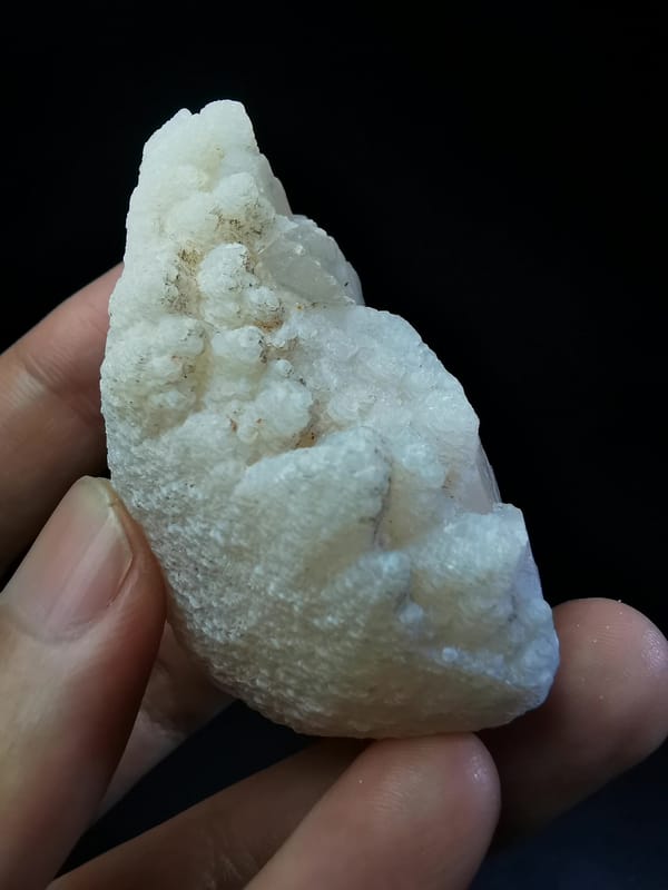 Complete pale pink calcite face with fine layered texture
