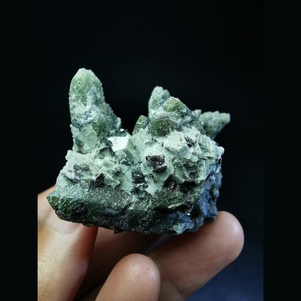 Green quartz cluster with a green calcite ball and hematite — detail view