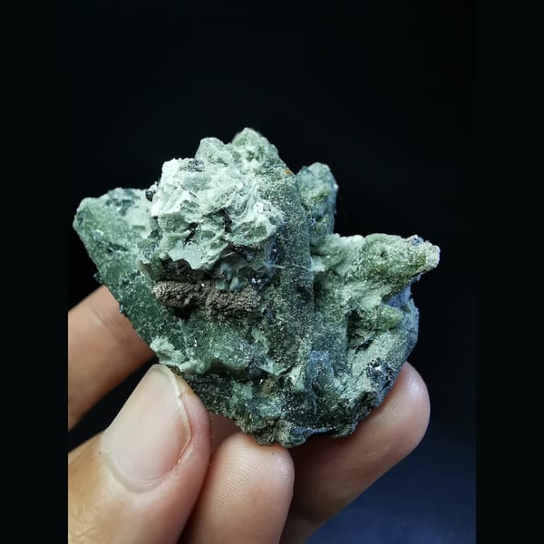 Green quartz cluster with a green calcite ball and hematite — detail view
