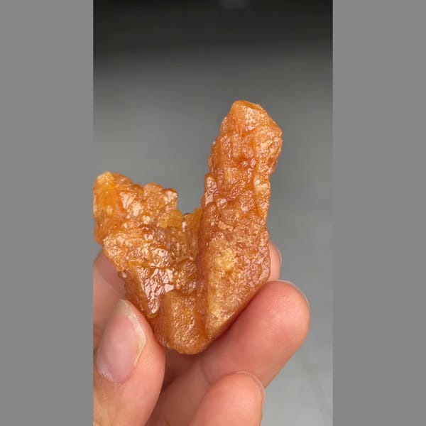 Unusual V-shaped orange scheelite formation from Xuebaoding — complete view