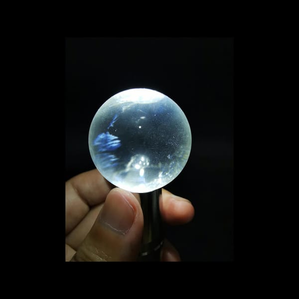 Clear quartz sphere with blue needle inclusions — alternate view