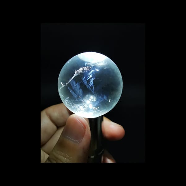 Clear quartz sphere with blue needle inclusions — alternate view