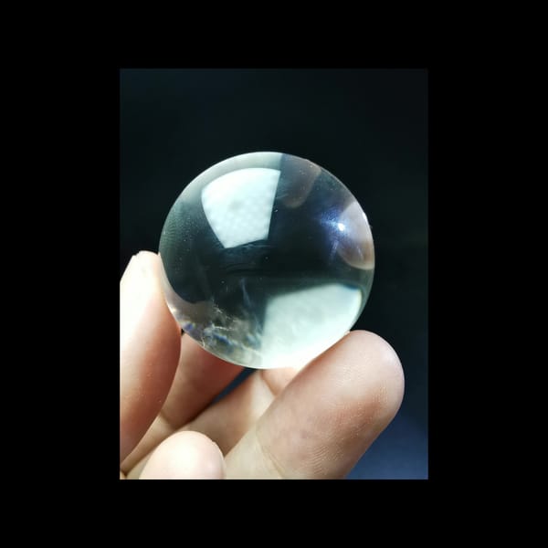 Clear quartz sphere with blue needle inclusions — detail view