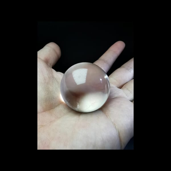 Clear quartz sphere with blue needle inclusions — detail view