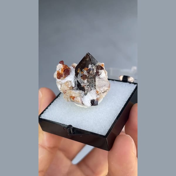 Small smoky quartz with spessartine garnet and hyalite from Yunxiao, Fujian — detail view