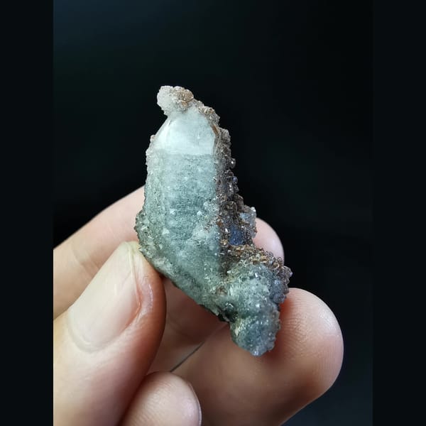Quartz crystal with red-brown tower-shaped calcite — alternate view