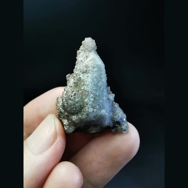 Quartz crystal with red-brown tower-shaped calcite — alternate view