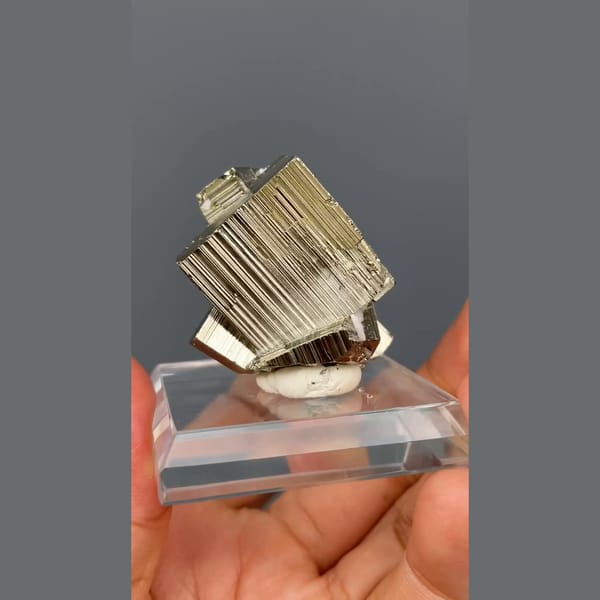 Bright striated cubic pyrite crystals from Peru on a clear stand — alternate view