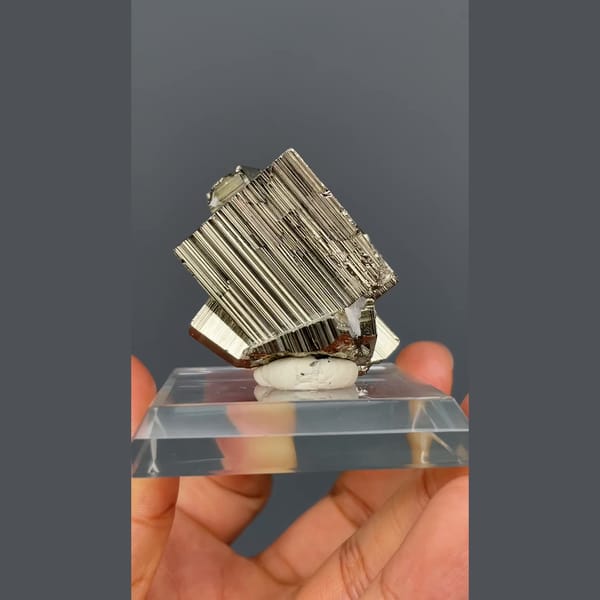 Bright striated cubic pyrite crystals from Peru on a clear stand — alternate view