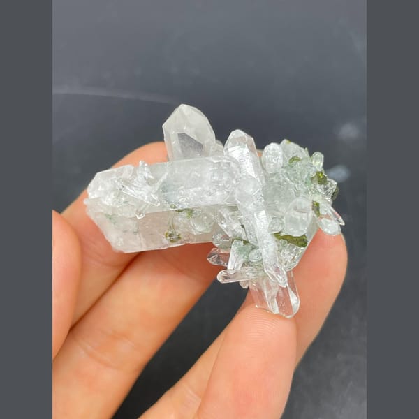 Clear quartz crystals with green epidote from Meigu — alternate view