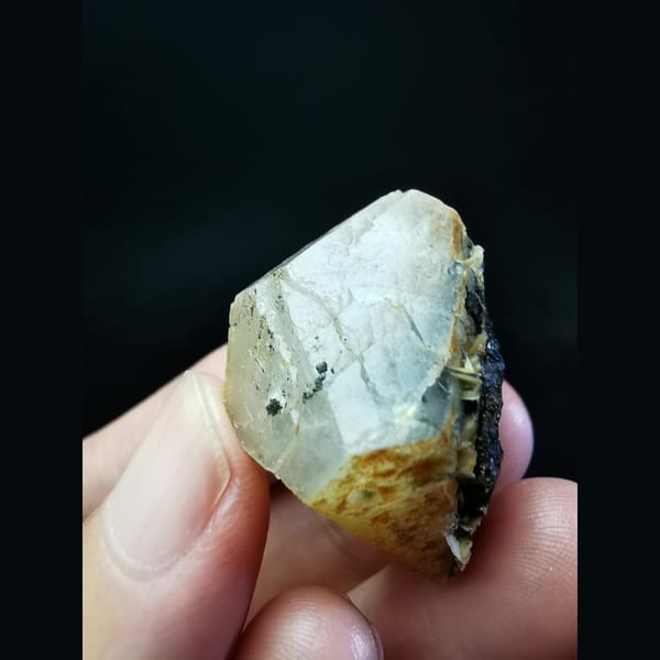 Calcite crystal with pyrite and hematite at the base — complete view